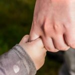 child holding hand of another person