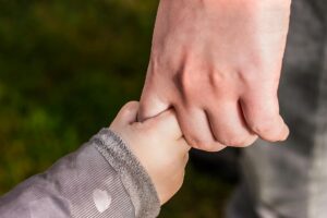 child holding hand of another person