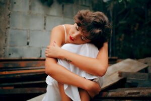 woman squatting near gray concrete wall