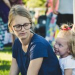 girl behind woman near folding chair