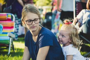 girl behind woman near folding chair