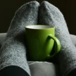 green ceramic mug on person s feet