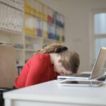 woman sitting on chair while leaning on laptop