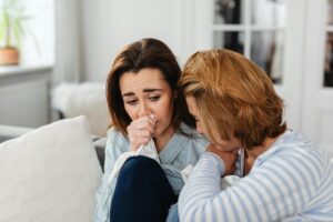 two women friends crying at home